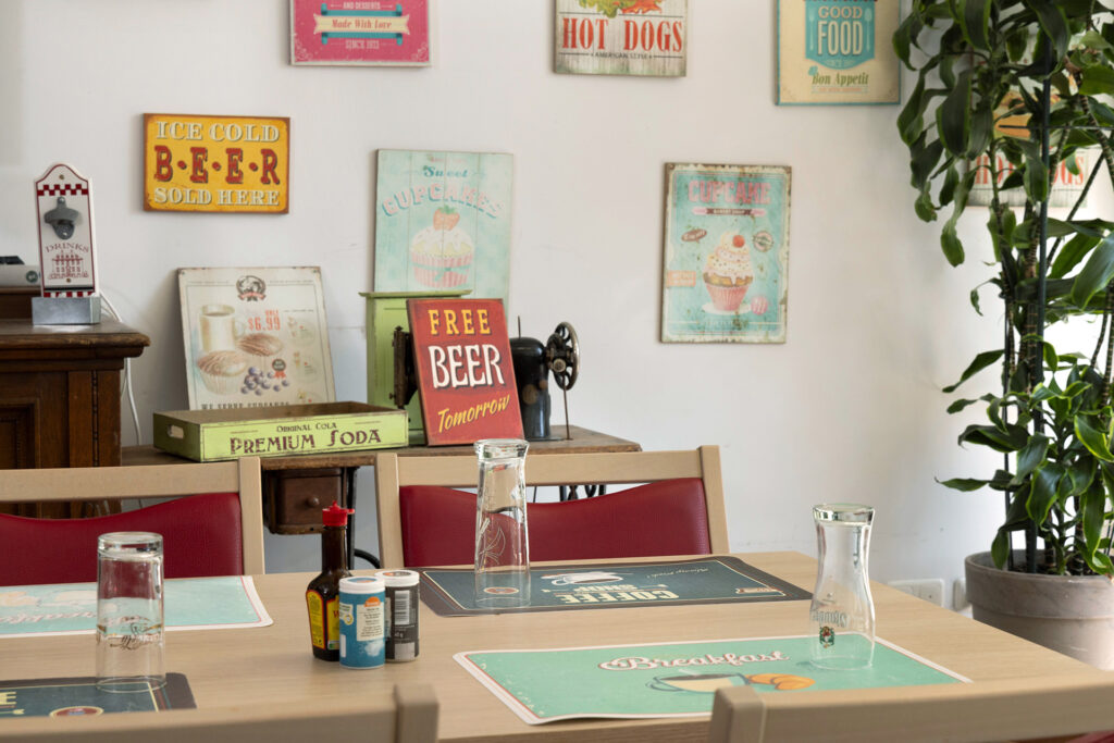 Tische und Wände sind mit amerikanischen Vintage-Schildern und Tischsets dekoriert.