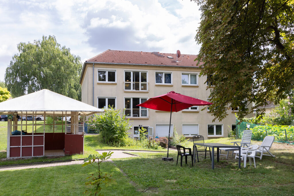 Blick auf einen Teil des großen Gartens und eine Seite des Haus am Hedwig Dransfeld Platz