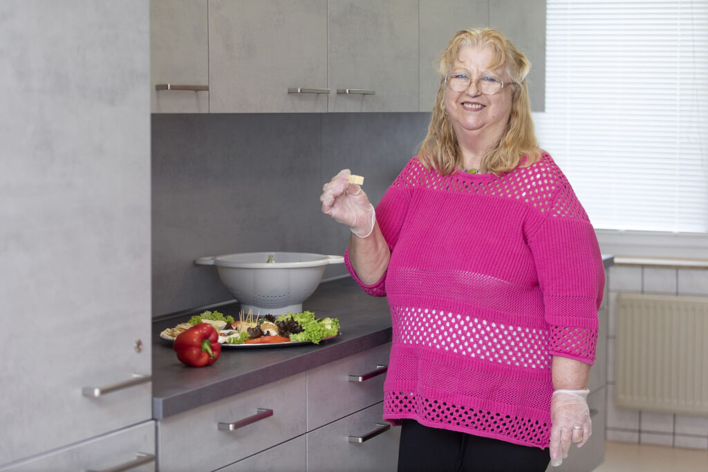 Eine Bewohnerin kostet von dem vorher zusammengestellten Rohkostteller