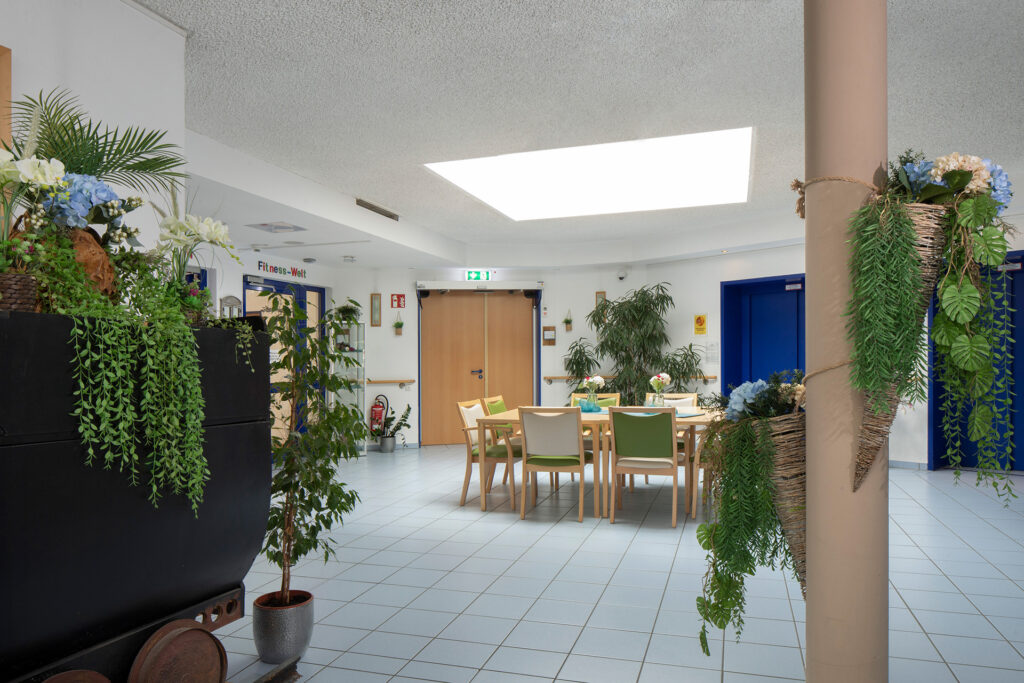 Blick in den großzügigen Eingangsbereich des Hospital zum Heiligen Geist, in dem viele Grünpflanzen stehen.