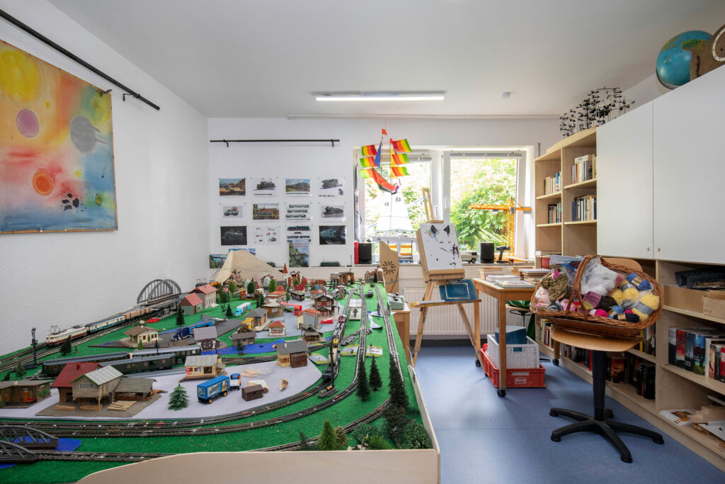 Blick in einen Raum, in dem unter anderem eine große Modellbaueisenbahn aufgebaut ist.