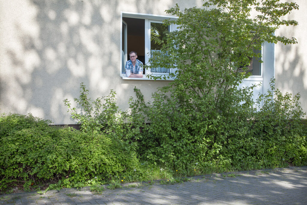 Blick auf das Männerwohnheim: Ein Bewohner blickt aus dem Fenster.