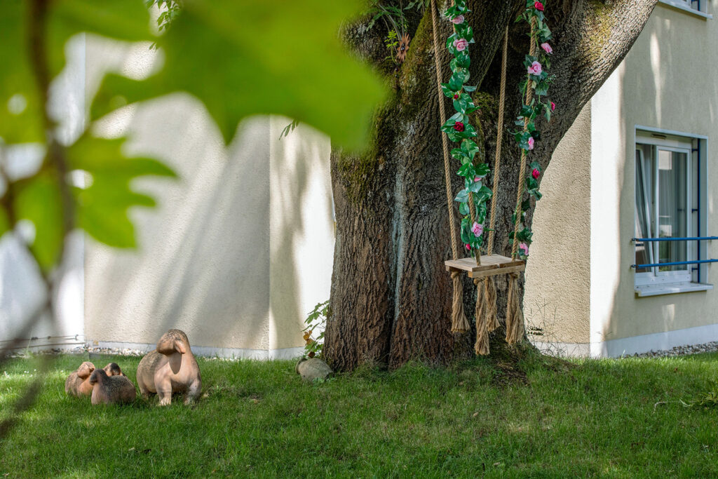 Der Außenbereich ist mit verschiedenen Elementen, wie Figuren und einer Holzschaukel dekoriert.