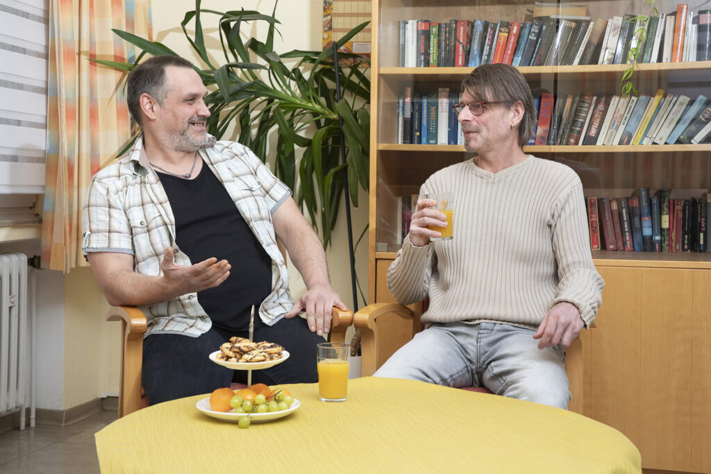 Zwei Bewohner unterhalten sich im Aufenthaltsraum.