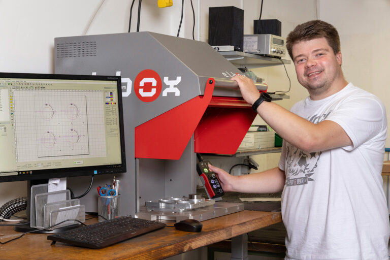 Ein Werkstattmitarbeiter bedient eine große Maschine.