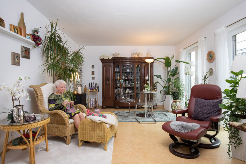 Blick in einen Wohn- und Essbereich: Die bodentiefen Fenster lassen viel Tageslicht in den Raum, der ansprechend mit einem Esstisch sowie bequemen Sesseln möbiliert ist.
