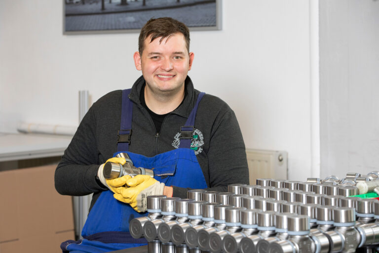 Ein Werkstattmitarbeiter lächelt während seiner Arbeit in der GSE-Werkstatt Holsterhausen freundlich in die Kamera