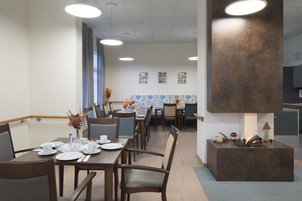 Blick in die modern eingerichtete und helle Tagespflege Rathaus Rellighausen: Ein Kamit sorgt für eine gemütliche Atmosphäre.