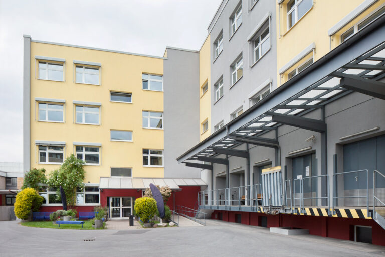 Blick auf den Innenhof der GSE-Werkstatt Holsterhausen mit Bepflanzung und der Anlieferungsrampe