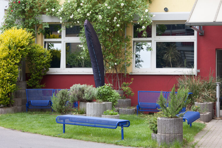 Sitzgelegenheiten im Außenbereich und Bepflanzung bieten einen gemütlichen Pausenplatz.