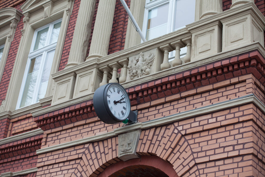 Über dem historischen Eingangsbereich des Rathaus Rellinghausen hängt eine große Uhr.