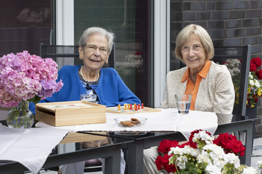 Zwei Seniorinnen sitzen auf der Terrasse der Tagespflege Stoppenberg.
